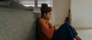 Woman leaning against couch showing anxiety