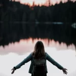 Woman's Arms Open by a lake.