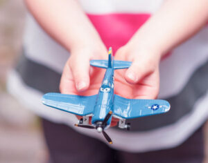 Child holding toy airplane in their hands